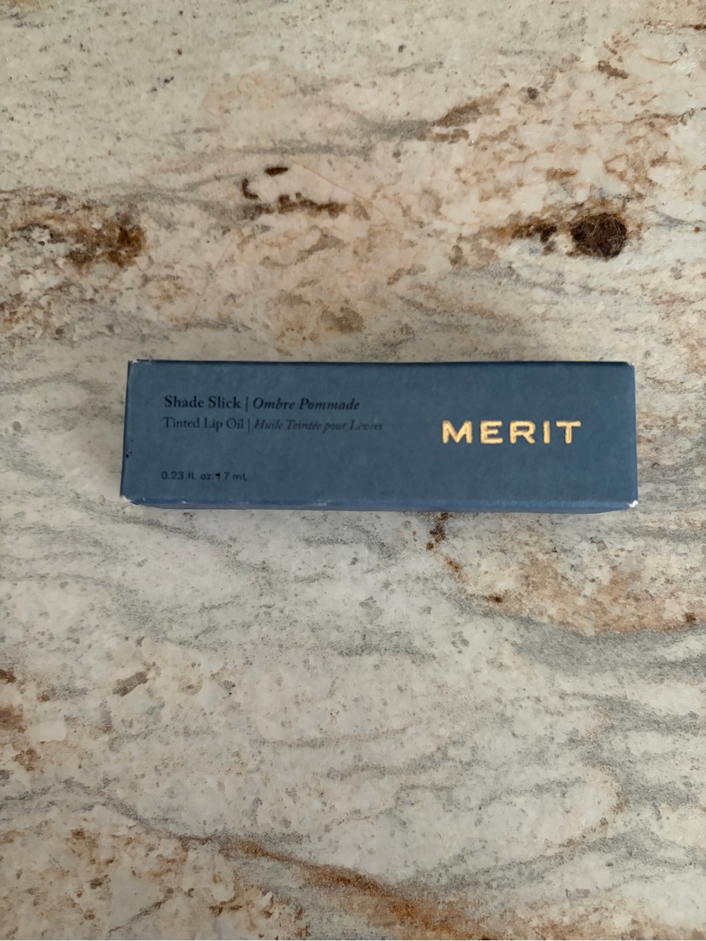 Merit Shade Slick Tinted Lip Oil in Blue Packaging